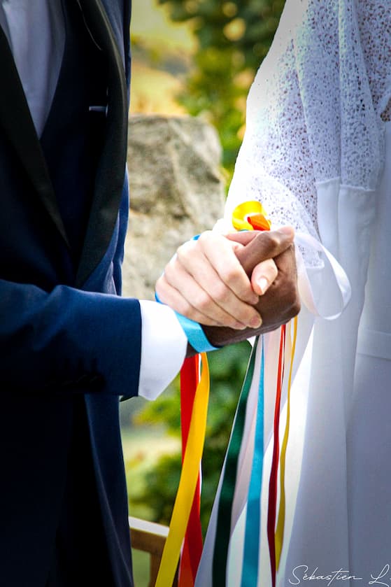 Mains des mariés jointes avec ruban de cérémonie laique